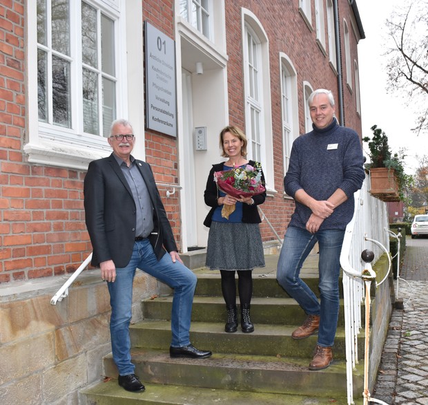 v. li.: Drei Personen: Thomas Voß (Kaufmännischer Direktor), Dr. Britta Jüngst (Seelsorgerin), Michael Lison (Pflegedirektor) stehen auf einer Treppe
