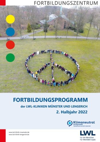 Titelseite Fortbildungsprogramm: Luftbildaufnahme zeigt eine Menschengruppe von 150 Personen, die das Friedenszeichen auf einer grünen Wiesen bilden.