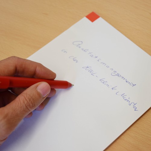 Mitarbeiterin macht sich auf einem Block Notizen.